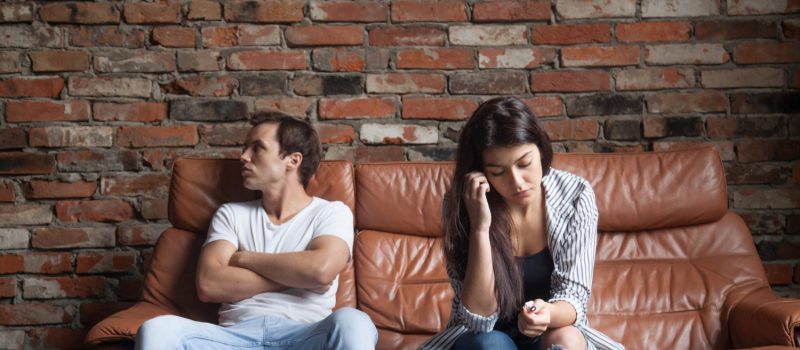 frustrated-upset-couple-after-quarrel-sitting-sofa-home